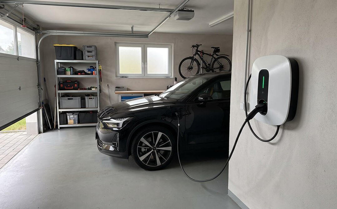 11kW Wallbox an der Garagenwand eines Eigenheims mit geladenem Elektroauto